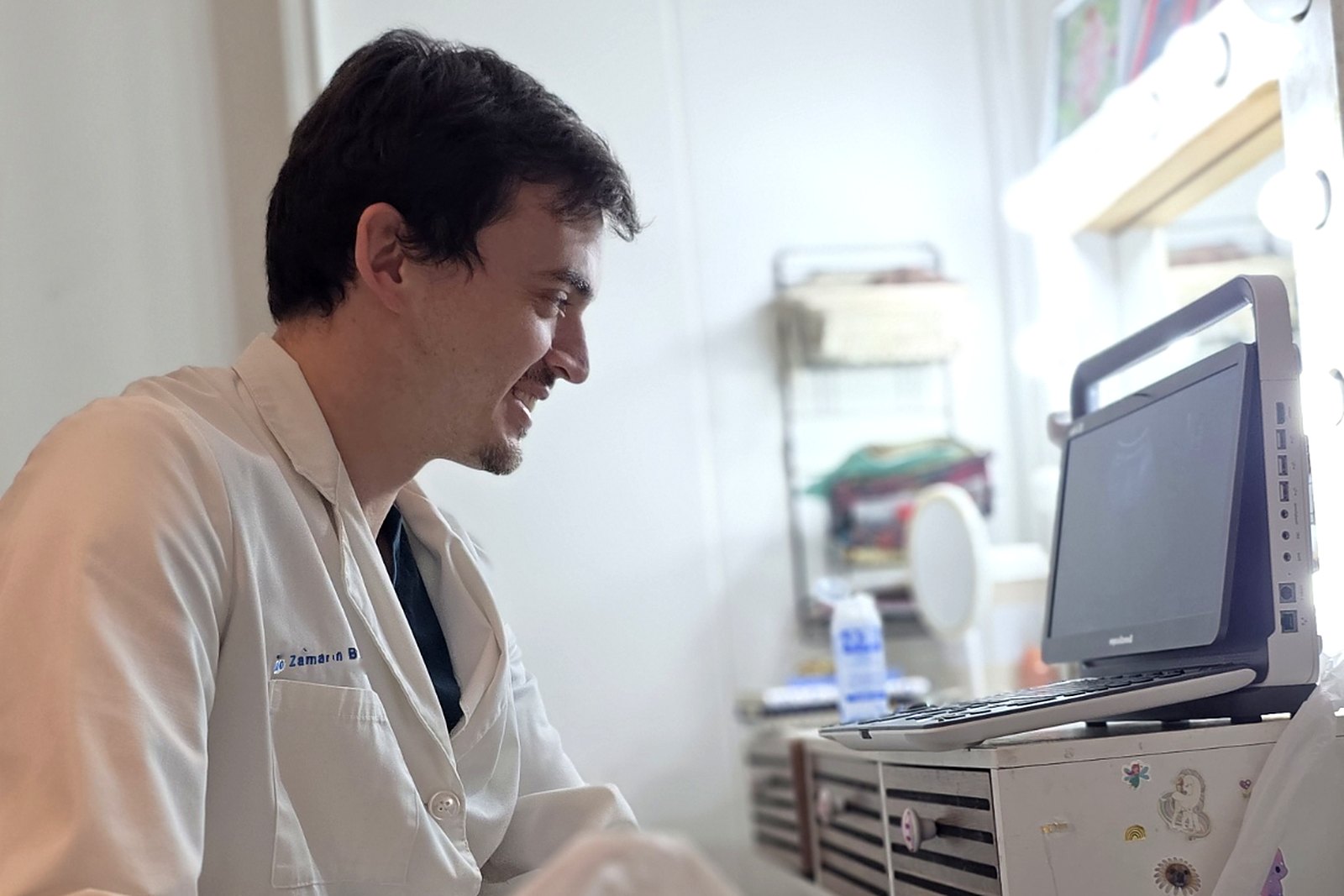 Médico radiólogo infantil realizando una ecografía a un lactante en su casa